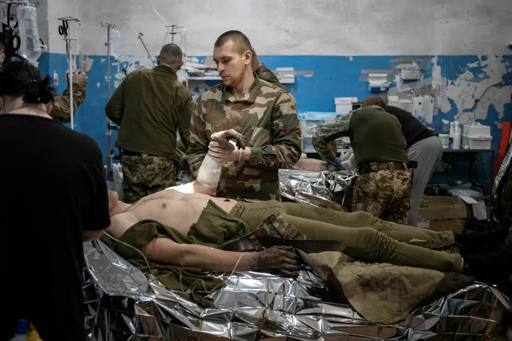 Medics treat wounded Ukrainian soldiers inside a frontline medical stabilisation point, amid Russia's attack on Ukraine, near Vuhledar, Donetsk region, Ukraine, February 19, 2023. Nearly a year into Russia's invasion, fighting now amounts to attritional duels of artillery and infantry assaults, with neither side making significant gains. The costs of that deadly grind are clear to the team of medics and nurses as it toils away, hemmed in by racks of medical supplies and portable heaters, at this stabilisation point in the Donetsk region where battles are fierce. REUTERS/Marko Djurica   SEARCH "DJURICA UKRAINE MEDICS" FOR THIS STORY. SEARCH "WIDER IMAGE" FOR ALL STORIES. TPX IMAGES OF THE DAY