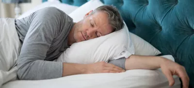Man sleeping on bed in bedroom at home