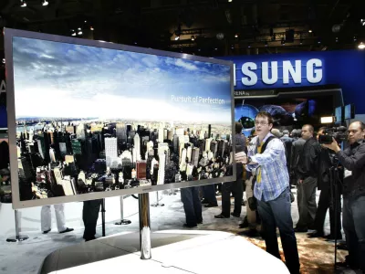 A reporter touches a 75-inch, full HD 3D LED television by Samsung Electronics during the first day of the 2011 International Consumer Electronics Show (CES) in Las Vegas, Nevada January 6, 2011. REUTERS/Steve Marcus (UNITED STATES - Tags: BUSINESS)