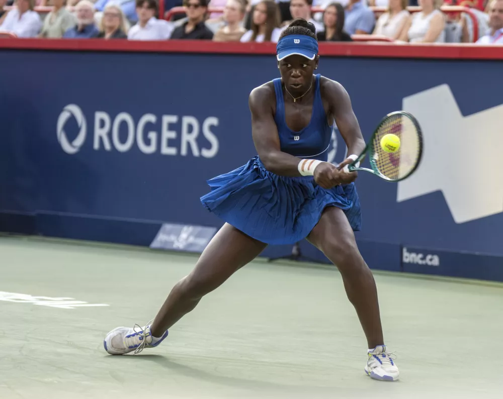 Victoria Mboko, of Canada, hits a return to Naomi Osaka, of Japan, during final action at the National Bank Open women's tennis tournament in Montreal, Thursday, Aug. 7, 2025. (Christinne Muschi/The Canadian Press via AP)