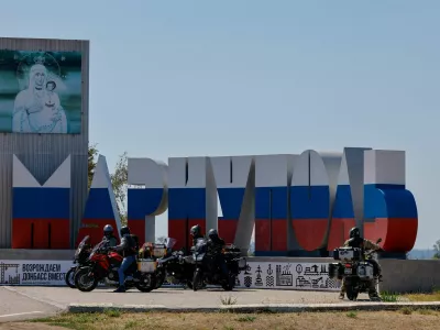 Bikers arrive at a stele with the city name painted in the colours of the Russian state flag amid Russia-Ukraine military conflict, in Mariupol, a Russian-controlled city of Ukraine, August 6, 2025. REUTERS/Alexander Ermochenko