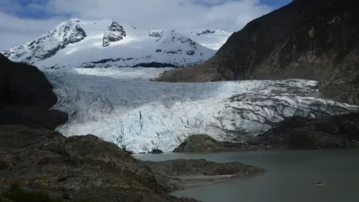 FILE - A canoe, bottom right, glides on Mendenhall Lake, in front of the Mendenhall Glacier, on Sunday, May 18, 2025, in Juneau, Alaska. (AP Photo/Becky Bohrer, File)