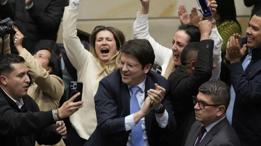 FILE - Miguel Uribe Turbay, center in blue tie, a Colombian senator and presidential candidate for the right-wing Centro Democr&aacute;tico party, celebrates after voting against a labor reform referendum proposed by the government, in Bogota, Colombia, May 14, 2025. (AP Photo/Fernando Vergara, File)