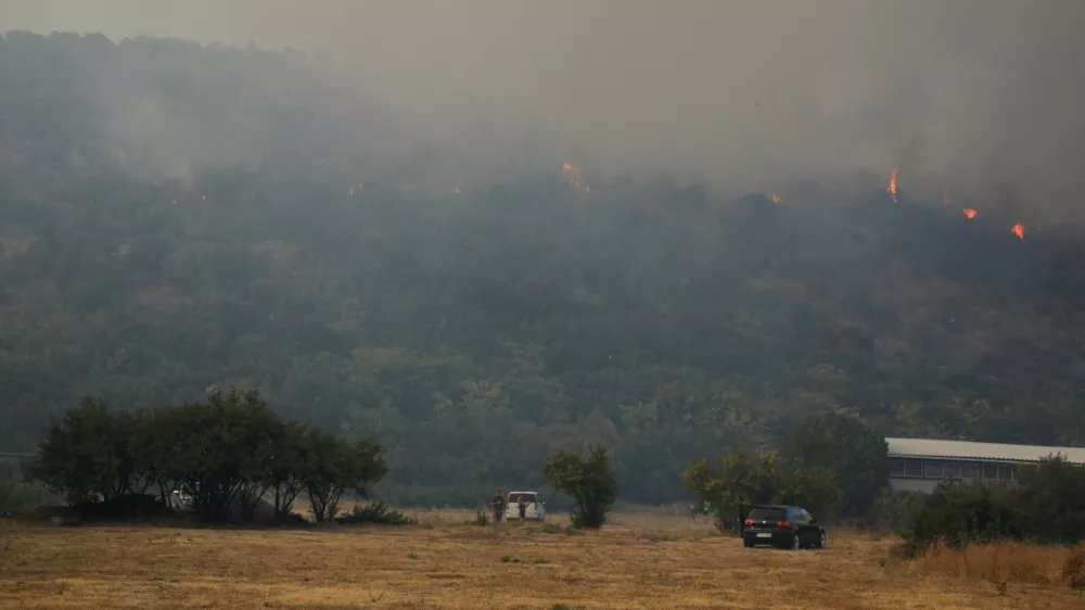 Residents watch wildfires burn above Rogami suburbs, as temperature rises during a heatwave in Podgorica, Montenegro, August 11, 2025. REUTERS/Stevo Vasiljevic