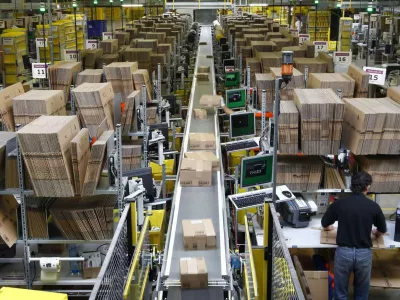 Workers pack boxes at Amazon's logistics centre in Graben near Augsburg December 16, 2013. Workers at Amazon.com's German operations were set to go on strike on Monday, in the middle of the crucial Christmas holiday season, in a dispute over pay that has been raging for months. The Verdi union said workers would strike in Amazon's logistic centres in Bad Hersfeld and Leipzig and, for the first time, in Graben. REUTERS/Michaela Rehle (GERMANY - Tags: BUSINESS EMPLOYMENT)