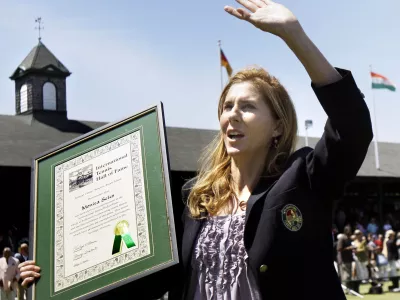 FILE - International Tennis Hall of Fame inductee Monica Seles waves to the crowd as she holds her plaque during ceremonies in Newport, R.I., July 11, 2009. (AP Photo/Elise Amendola, file)