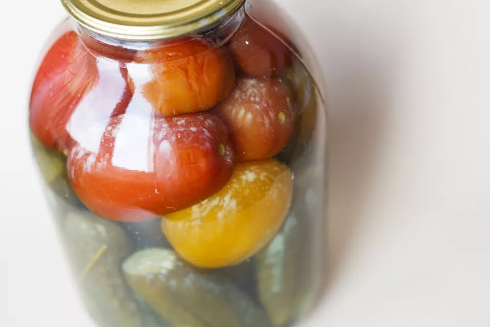 spoiled can of vegetable seaming. Glass jar with homemade pickled tomatos and cucumbers with white fungus and mold / Foto: Lolkaphoto