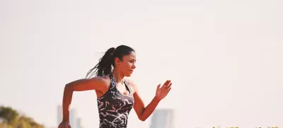 Sport girl in sporty outfit running at the lane in the park