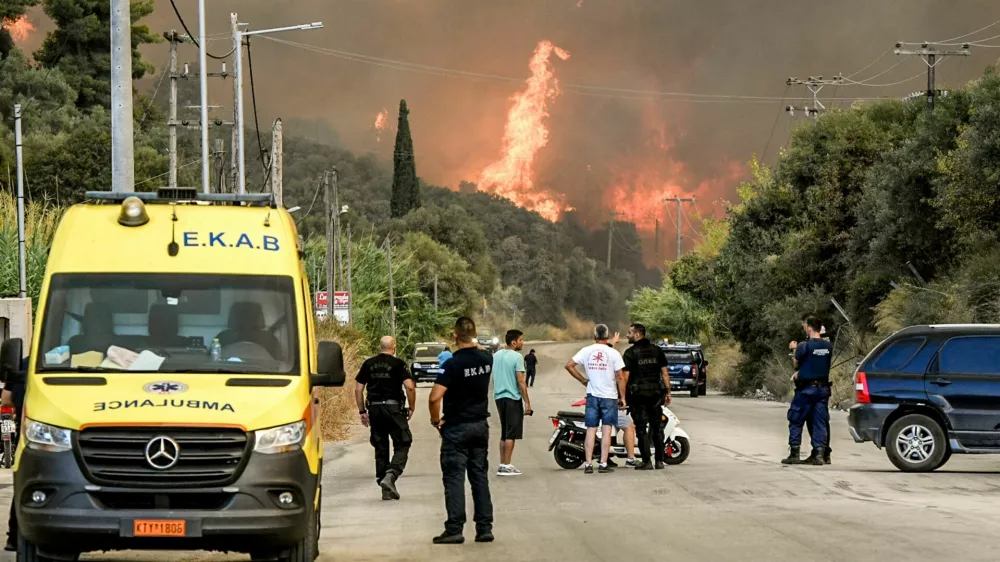 People watch as a wildfire burns in Achaia, Greece, August 12, 2025. Eurokinissi via REUTERS ATTENTION EDITORS - THIS PICTURE WAS PROVIDED BY A THIRD PARTY. NO RESALES. NO ARCHIVES. GREECE OUT. NO COMMERCIAL OR EDITORIAL SALES IN GREECE