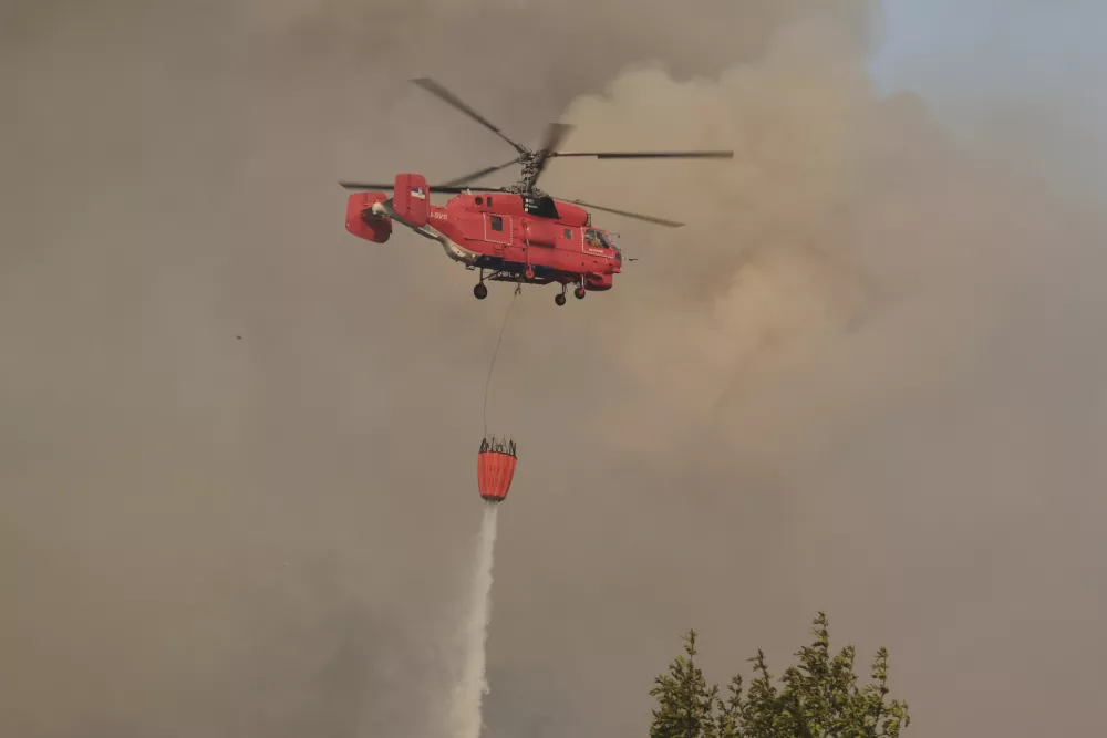 A Serbian firefighters helicopter battles a fire north-east of Montenegro capital Podgorica, Tuesday, Aug. 12, 2025. (AP Photo/Risto Bozovic)