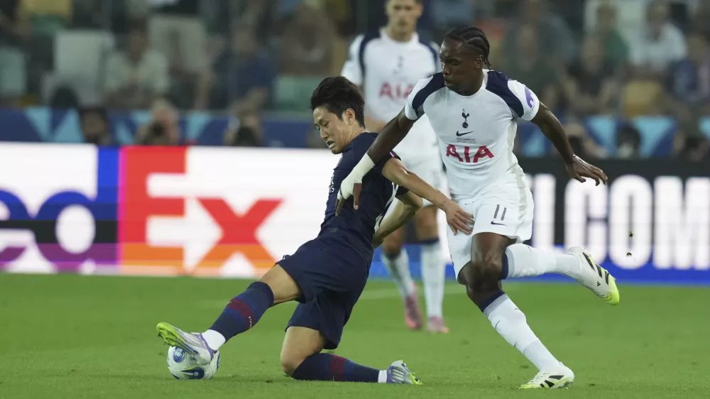 PSG's Kang-in Lee, left, and Tottenham's Mathys Tel challenge for the ball during the UEFA Super Cup soccer match between Paris Saint-Germain and Tottenham Hotspur in Udine, Italy, Wednesday, Aug. 13, 2025. (AP Photo/Antonio Calanni)