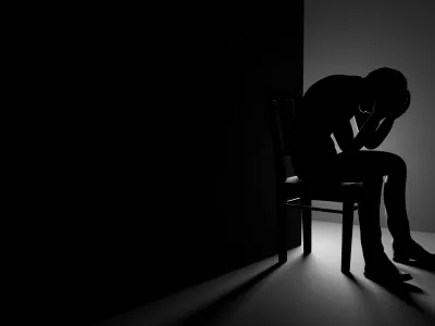 3D Man Sitting on Chair in a Dark Room, Depression or Anxiety Concept Illustration / Foto: Evilwata