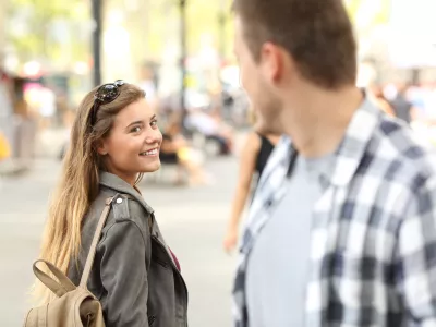 Strangers girl and guy flirting looking each other on the street / Foto: Antonioguillem