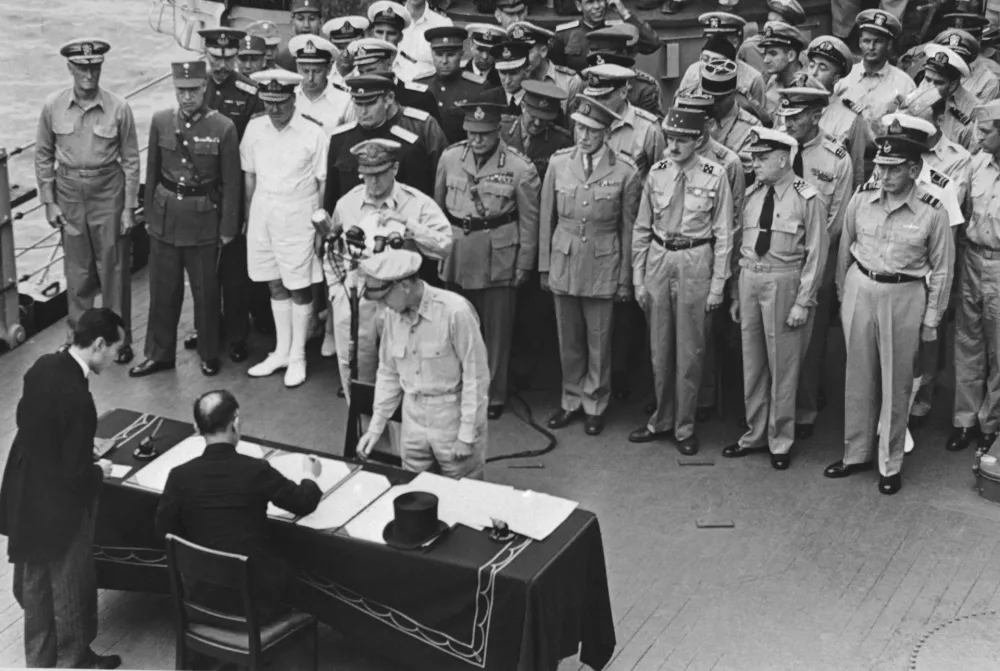 FILE - Then Japanese Foreign Minister, Mamoru Shigemitsu signs the Japanese unconditional surrender papers for Emperor Hirohito aboard the U.S.S. Missouri in Tokyo harbor on Sept. 2, 1945. (AP Photo, File)