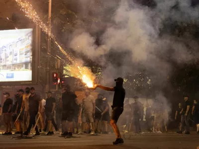 A person fires fireworks, during a standoff between supporters of the ruling party and anti-government protesters in Belgrade, Serbia, August 14, 2025. REUTERS/Djordje Kojadinovic