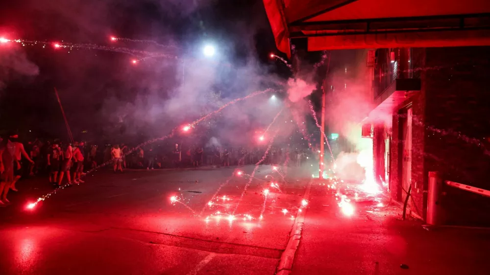 Anti-government protesters throw fireworks at the offices of the ruling Serbian Progressive Party (SNS), during a protest in Valjevo, Serbia, August 16, 2025. REUTERS/Zorana Jevtic   TPX IMAGES OF THE DAY