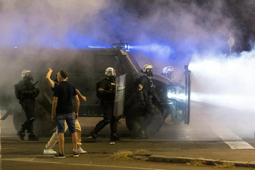 Protesters react next to police officers deployed during anti-government demonstrations in Belgrade, Serbia, August 16, 2025. REUTERS/Djordje Kojadinovic   TPX IMAGES OF THE DAY