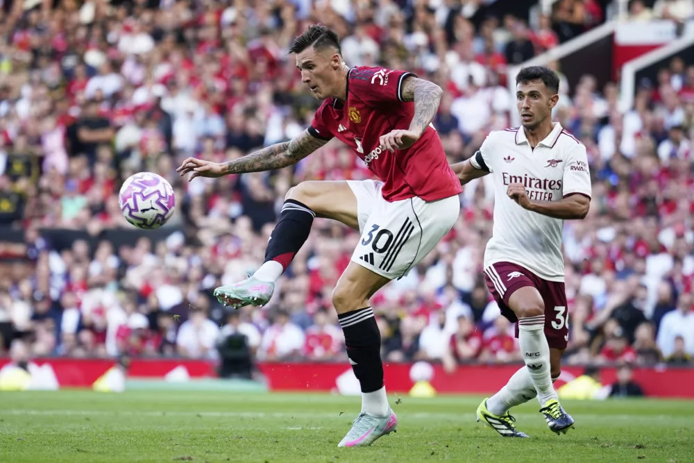 Arsenal's Martin Zubimendi, right, challenges Manchester United's Benjamin Sesko during the English Premier League soccer match between Manchester United and Arsenal at Old Trafford stadium in Manchester, England, Sunday, Aug. 17, 2025. (AP Photo/Dave Thompson)