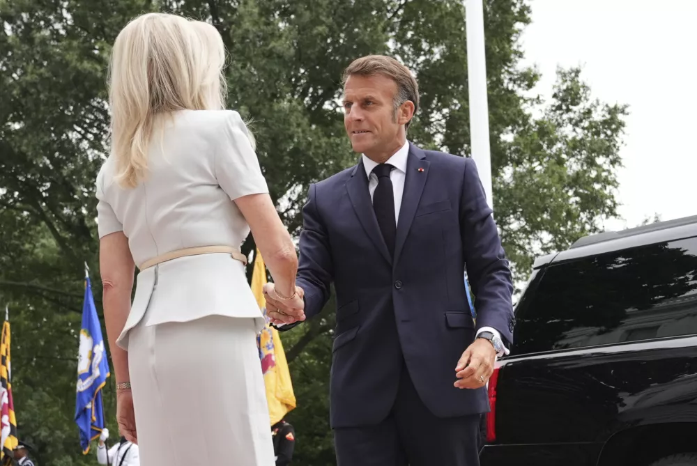 Monica Crowley, White House chief of protocol, left, greets France's President Emmanuel Macron upon arriving to meet with President Donald Trump and Ukraine's President Volodymyr Zelenskyy, Monday, Aug. 18, 2025, at the South Portico of the White House in Washington. (AP Photo/Jacquelyn Martin)