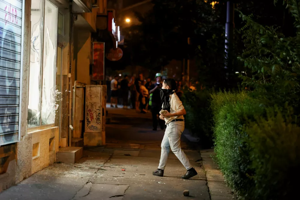 Anti-government protesters throw stones toward the offices of the ruling Serbian Progressive Party (SNS) during an anti-government protest in Belgrade, Serbia, August 18, 2025. REUTERS/Zorana Jevtic