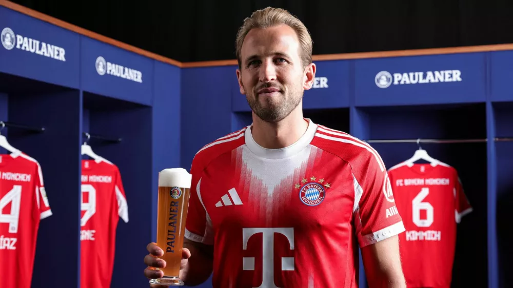 Soccer Football - Bayern Munich's Harry Kane poses with a glass of beer in a traditional photoshoot held annually before the Oktoberfest beer festival - Munich, Germany - August 19, 2025. Christina Pahnke/Bayern Munich and Paulaner/Handout via REUTERS. ATTENTION EDITORS - THIS IMAGE HAS BEEN SUPPLIED BY A THIRD PARTY.