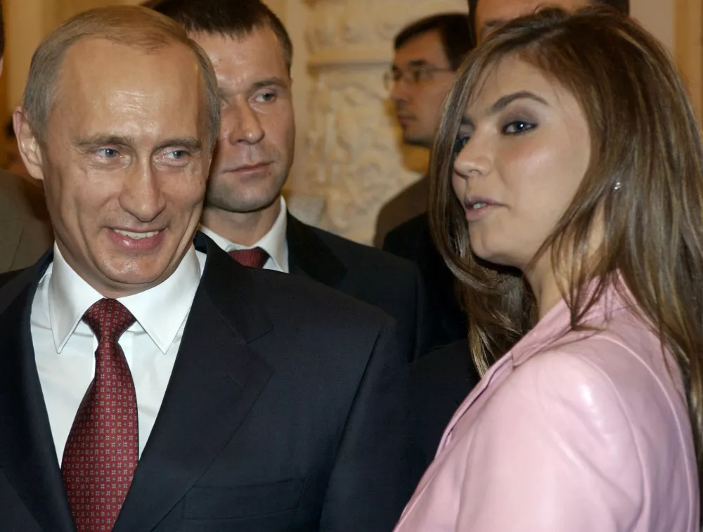 President Vladimir Putin, left, speaks with gymnast Alina Kabayeva as he hosts Russia's Olympic athletes at a Kremlin banquet in Moscow, Thursday, Nov. 4, 2004. Vladimir Putin on Thursday congratulated the country's Olympic team on their strong showing in Athens and stressed the importance of a healthy lifestyle. (AP Photo/ITAR-TASS, Presidential Press Service)