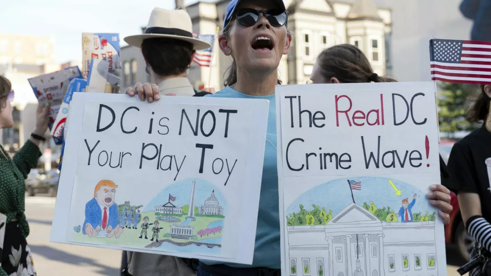 A demonstrator protest against President Donald Trump's use of federal law enforcement and National Guard troops in the city during a rally along the U street corridor in northwest Washington, Saturday, Aug. 23, 2025. (AP Photo/Jose Luis Magana)