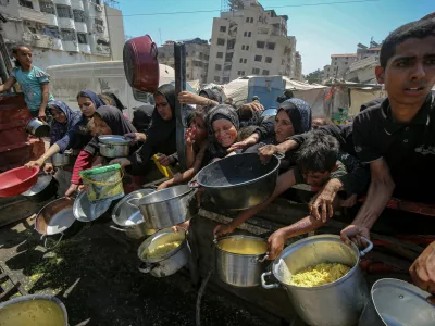 24 August 2025, Palestinian Territories, Gaza: Palestinians wait to receive food from a charity kitchen, amid the on going famine. The United Nations has warned that ''the entire population of Gaza is facing the risk of famine'' since Israel closed border crossings on 02 March 2025, preventing the entry of essential supplies. Photo: Omar Ashtawy/APA Images via ZUMA Press Wire/dpa