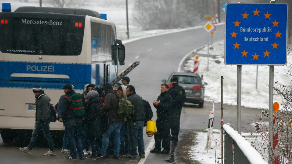 Migrants walk during snowfall before passing Austrian-German border in Wegscheid in Austria, near Passau November 22, 2015. REUTERS/Michael Dalder - RTX1VA39