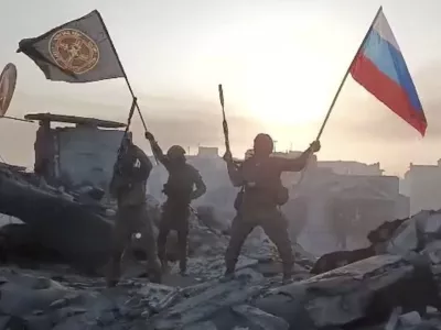 Wagner mercenary group fighters wave flags of Russia and Wagner group on the top of a building in an unidentified location in the course of Russia-Ukraine conflict, in this still image taken from video released on May 20, 2023, along with a statement by Russian mercenary chief Yevgeny Prigozhin about taking full control of the Ukrainian city of Bakhmut. Press service of "Concord"/Handout via REUTERS ATTENTION EDITORS - THIS IMAGE WAS PROVIDED BY A THIRD PARTY. NO RESALES. NO ARCHIVES. MANDATORY CREDIT.