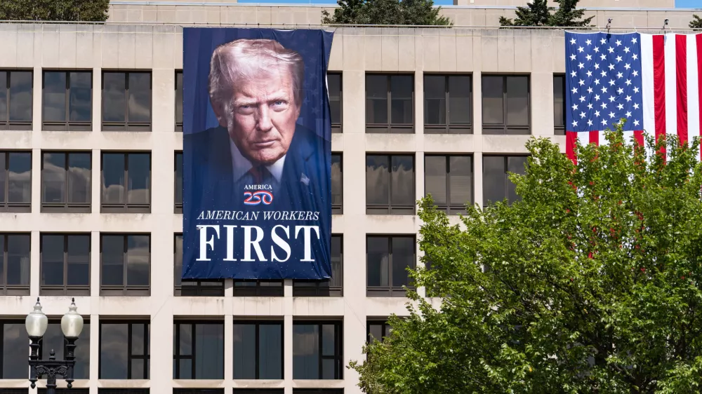 A portrait of President Donald Trump hangs on the Labor Department headquarters near the Capitol in Washington, Monday, Aug. 25, 2025. (AP Photo/J. Scott Applewhite)