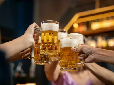 Close-up Group of People Holding Beer and Cheer in Restaurant. They Enjoying with Night Party Together. Party, Lifestyle, Happiness, Cheerful and Celebration Concept.