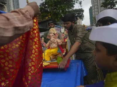 Devotees carry home an idol of elephant-headed Hindu god Ganesha for worship during Ganesh Chaturthi festival celebrations in Mumbai, India, Wednesday, Aug. 27, 2025. (AP Photo/Rafiq Maqbool)