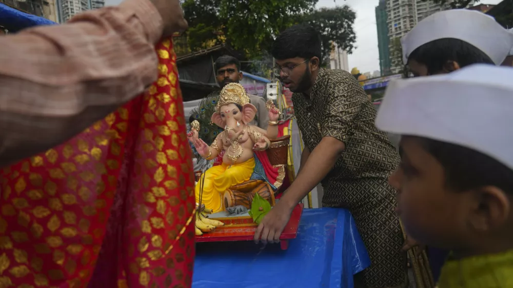 Devotees carry home an idol of elephant-headed Hindu god Ganesha for worship during Ganesh Chaturthi festival celebrations in Mumbai, India, Wednesday, Aug. 27, 2025. (AP Photo/Rafiq Maqbool)