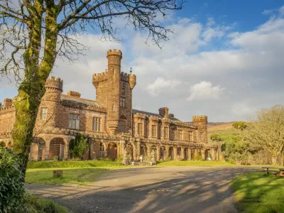 Kinloch Castle. See SWNS story SWOCcastle. July 29, 2021.One of Prince Charles' favourite castles is looking for a new owner to save it from ruin as the iconic landmark crumbles in need of repair. Kinloch Castle on the Island of Rum in Scotland is on the market for a new owner who could put the money required into fixing up the crumbling castle. With a nominal value of just &pound;1, this is an extremely rare opportunity to take ownership of a 120-year-old castle that Prince Charles himself has been passionate about saving. Repairs on the crumbling turreted red-sandstone house are estimated at an eye-watering &pound;20 million to restore the castle to it's former glory. A private individual or a charity, foundation or private company who can provide such an amount for the castle repairs are in with a chance of owning the incredible house. Any new hopeful owners will have to prove that they have the resources to save this Category A landmark and show plans for bettering the future of the small isle where the castle sits.,Image: 624152990, License: Rights-managed, Restrictions: This image is not available for use at a stock rate unless with prior agreement. This image hereby disclosed to your organisation is so disclosed on the condition that your organisation will take all steps necessary to ensure that any identifiable personal data is processed in full compliance with the Data Protection Act 2018follow us on twitter - @swnsbrowse our website - swns.comemail pix@swns.com, Model Release: no