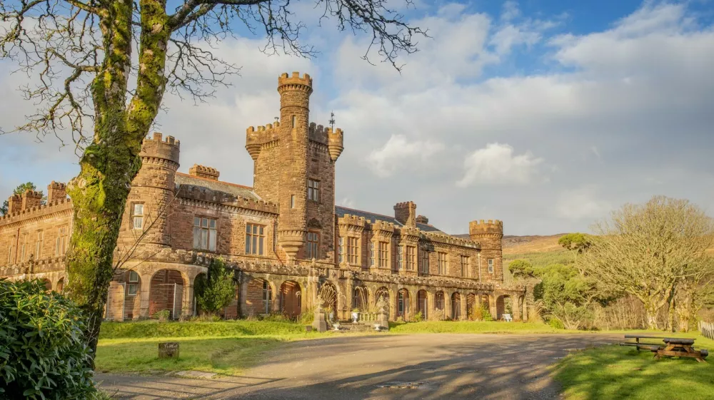 Kinloch Castle. See SWNS story SWOCcastle. July 29, 2021.One of Prince Charles' favourite castles is looking for a new owner to save it from ruin as the iconic landmark crumbles in need of repair. Kinloch Castle on the Island of Rum in Scotland is on the market for a new owner who could put the money required into fixing up the crumbling castle. With a nominal value of just &pound;1, this is an extremely rare opportunity to take ownership of a 120-year-old castle that Prince Charles himself has been passionate about saving. Repairs on the crumbling turreted red-sandstone house are estimated at an eye-watering &pound;20 million to restore the castle to it's former glory. A private individual or a charity, foundation or private company who can provide such an amount for the castle repairs are in with a chance of owning the incredible house. Any new hopeful owners will have to prove that they have the resources to save this Category A landmark and show plans for bettering the future of the small isle where the castle sits.,Image: 624152990, License: Rights-managed, Restrictions: This image is not available for use at a stock rate unless with prior agreement. This image hereby disclosed to your organisation is so disclosed on the condition that your organisation will take all steps necessary to ensure that any identifiable personal data is processed in full compliance with the Data Protection Act 2018follow us on twitter - @swnsbrowse our website - swns.comemail pix@swns.com, Model Release: no