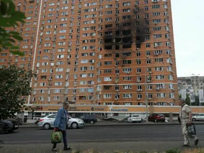 Residents walk in front of an apartment building hit by a Russian drone strike, amid Russia's attack on Ukraine, in Odesa, Ukraine June 28, 2025. REUTERS/Nina Liashonok