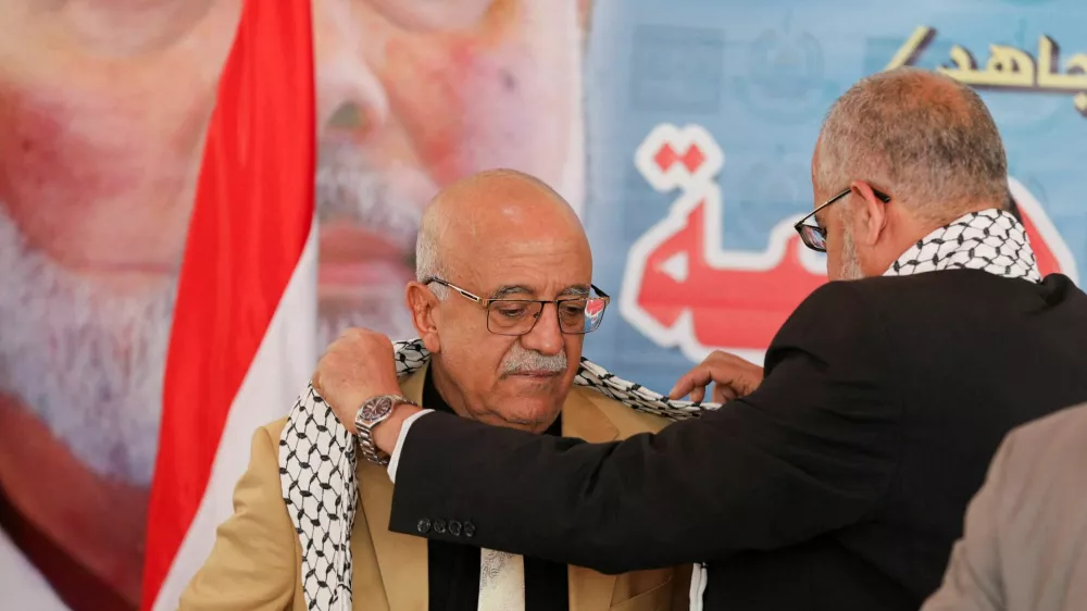 FILE PHOTO: Representative of Hamas in Yemen, Muadh Abu Shammalah, gives the head of Houthi-led government Ahmad al-Rahawi a Palestinian keffiyeh during his visit to the Hamas office in Sanaa, Yemen August 19, 2024. REUTERS/Khaled Abdullah/File Photo