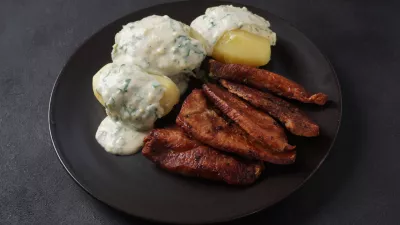Crispy fried pork with creamy parsley sauce and boiled potato in the plate on the table or stegt fl&aelig;sk, a classic Danish cuisine. / Foto: Nataly Hanin
