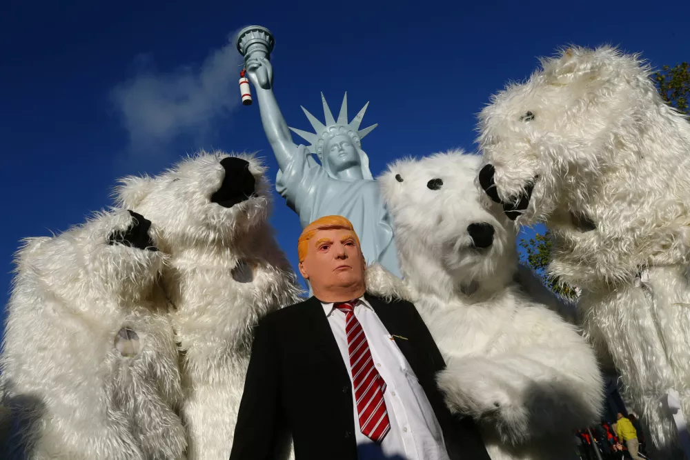 A protester wearing a mask of U.S. President Donald Trump stand along with other protesters dressed as polar bears during a demonstration under the banner "Protect the climate - stop coal" two days before the start of the COP 23 UN Climate Change Conference hosted by Fiji but held in Bonn, Germany November 4, 2017. REUTERS/Wolfgang Rattay   TPX IMAGES OF THE DAY