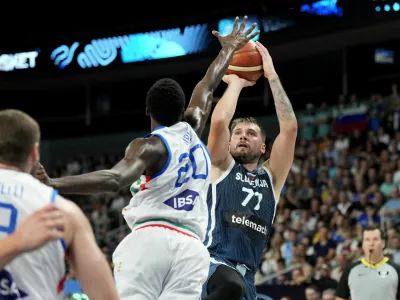 Basketball - FIBA EuroBasket 2025 - Round of 16 - Italy v Slovenia - Xiaomi Arena, Riga, Latvia - September 7, 2025 Italy's Saliou Niang in action with Slovenia's Luka Doncic REUTERS/Ints Kalnins