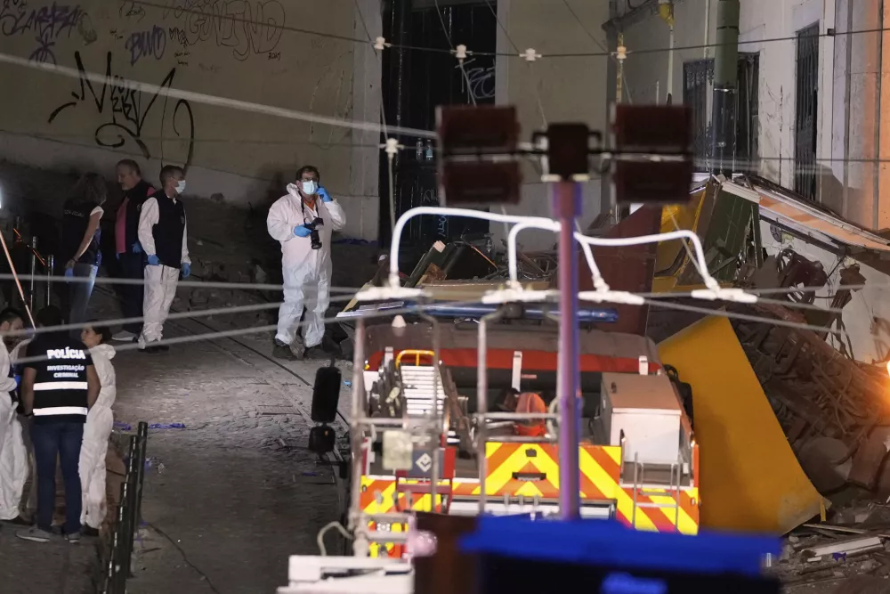Members of the judicial police work at the site of a derailed electric streetcar in Lisbon, Portugal, Wednesday, Sept. 3, 2025. (AP Photo/Armando Franca)