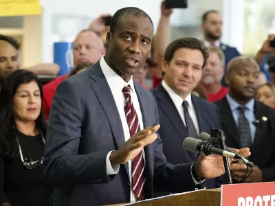 FILE - Florida Surgeon General Dr. Joseph Ladapo gestures as speaks to supporters and members of the media before a bill signing by Gov. Ron DeSantis, Nov. 18, 2021, in Brandon, Fla. (AP Photo/Chris O'Meara, File)