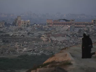 Palestinians look at the destruction caused by the Israeli air and ground offensive, in central Gaza Strip, Thursday, Sept. 4, 2025. (AP Photo/Jehad Alshrafi)