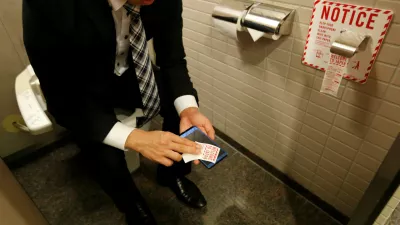 A man demonstrates a toilet roll for wiping smartphones, installed by Japanese mobile phone company NTT Docomo, in a high-tech bathroom equipped with bidet and heated seat at Narita international airport in Narita, Japan, December 28, 2016. REUTERS/Toru Hanai