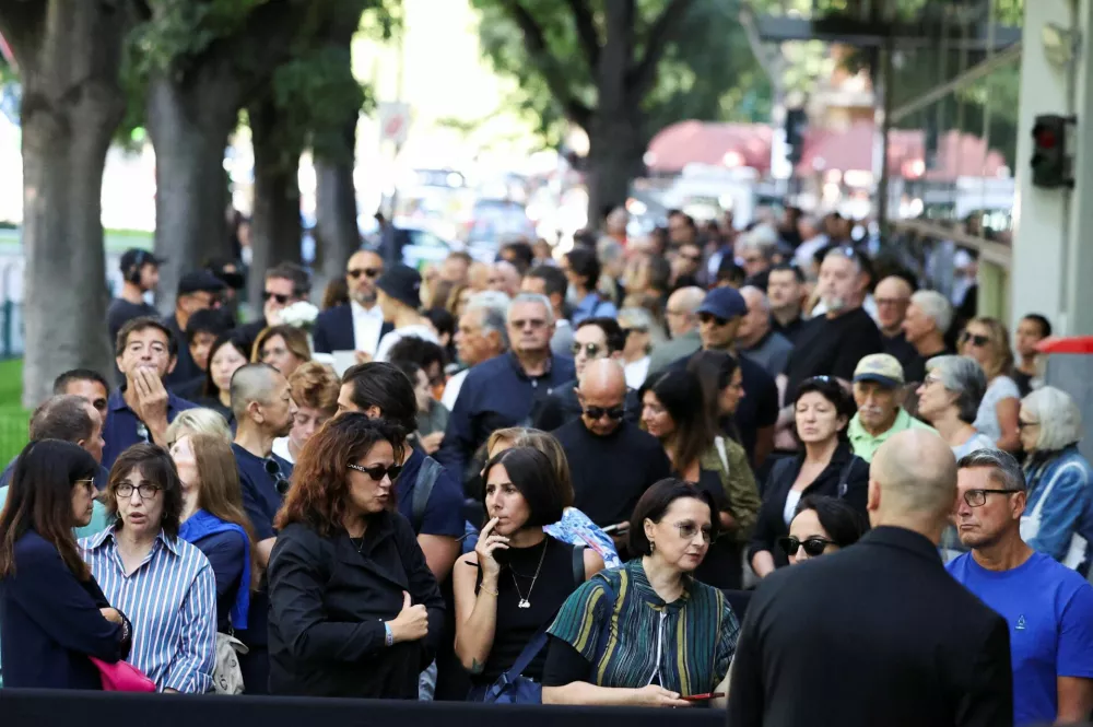 People queue outside the Armani/Teatro to pay tribute as designer Giorgio Armani lies in state, following his death at the age of 91, in Milan, Italy September 6, 2025. REUTERS/Claudia Greco