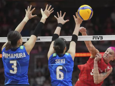Turkey's Ebrar Karakurt, right, spikes against Japan's Haruyo Shimamura, left, and Nanami Seki during the FIVB Women's Volleyball World Championship 2025 semifinal between Japan and Turkey at the Huamark Indoor Stadium in Bangkok, Thailand, Saturday, Sept. 6, 2025. (AP Photo/Sakchai Lalit)