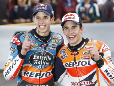 Moto 3 World Champion Alex Marquez of Spain, left, poses with his brother, Moto GP World Champion Marc Marquez of Spain after the Valencia Motorcycle Grand Prix, the last race of the season, at the Ricardo Tormo circuit in Cheste near Valencia, Spain, Sunday Nov. 9, 2014. (AP Photo/Alberto Saiz)