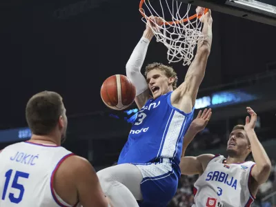 CORRECTS NAME TO LAURI MARKKANEN - Finland's Lauri Markkanen, center, and Serbia's Filip Petrusev in action during the Eurobasket, European Basketball Championship round of 16 match between Serbia and Finland at the Riga Arena in Riga, Latvia, Saturday, Sept. 6, 2025. (AP Photo/Sergei Grits)