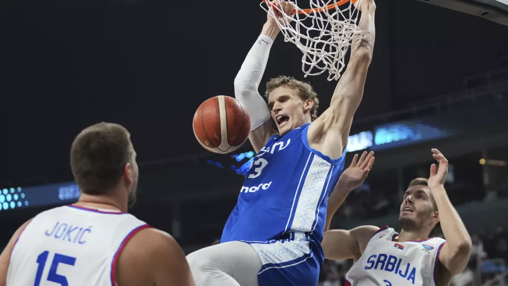 CORRECTS NAME TO LAURI MARKKANEN - Finland's Lauri Markkanen, center, and Serbia's Filip Petrusev in action during the Eurobasket, European Basketball Championship round of 16 match between Serbia and Finland at the Riga Arena in Riga, Latvia, Saturday, Sept. 6, 2025. (AP Photo/Sergei Grits)